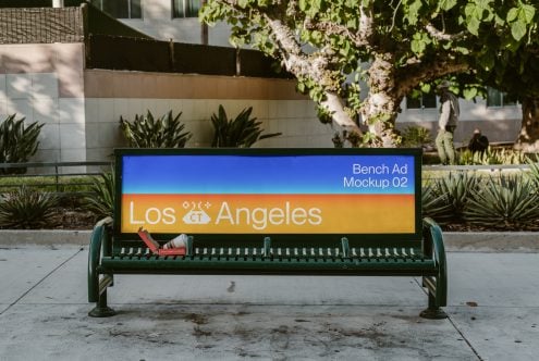 Green park bench with digital screen showing Los Angeles ad mockup in urban courtyard