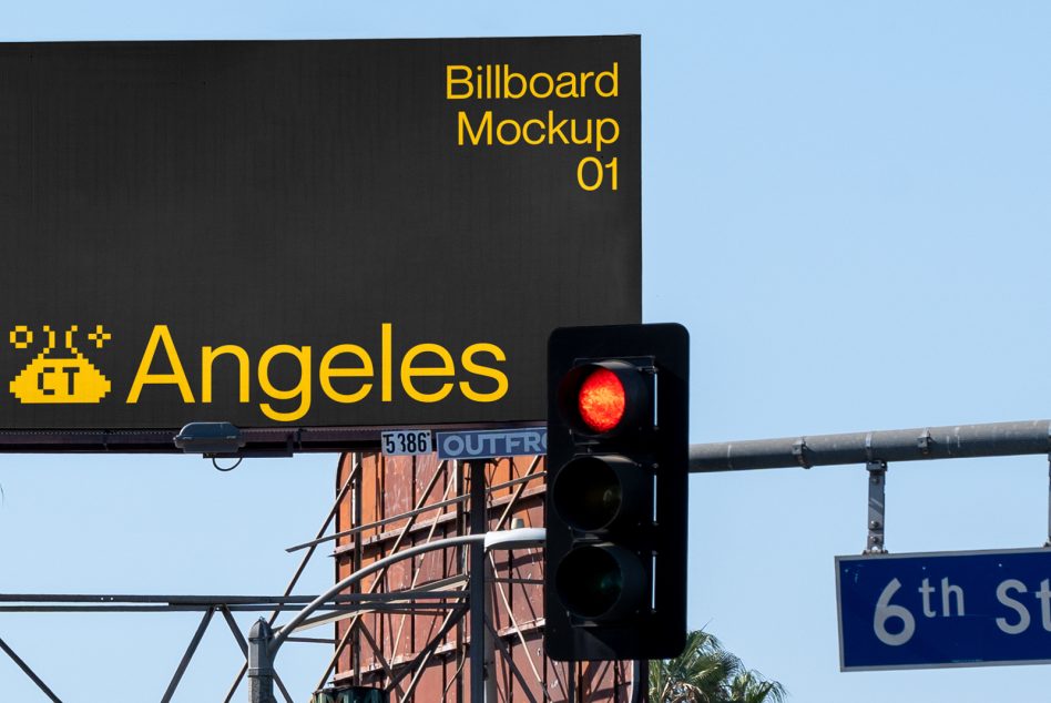 Dark billboard with yellow Los Angeles lettering beside red traffic light