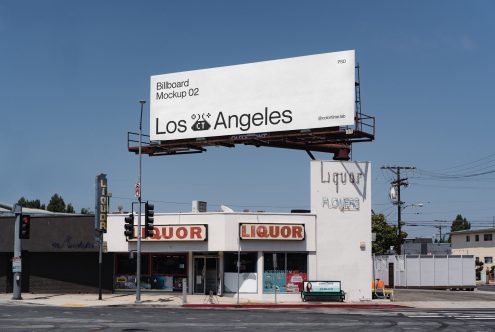 Large billboard with Los Angeles text on street corner above liquor store