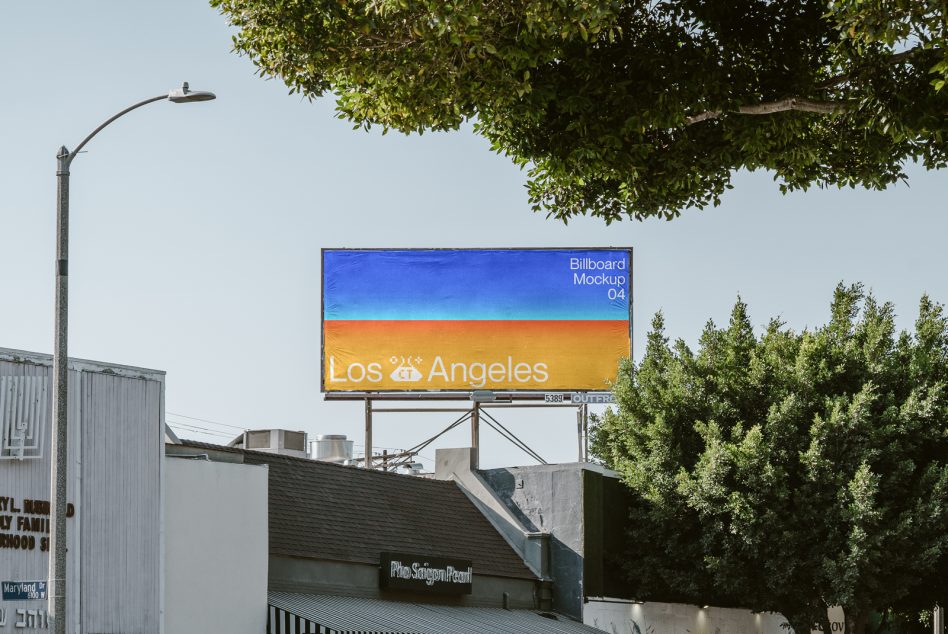 Gradient billboard transitioning blue to orange with Los Angeles beneath leafy trees