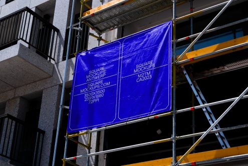 Bright blue illuminated banner on building scaffolding with yellow beams