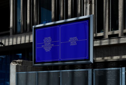 Outdoor billboard glowing with blue neon outline on industrial building facade at night