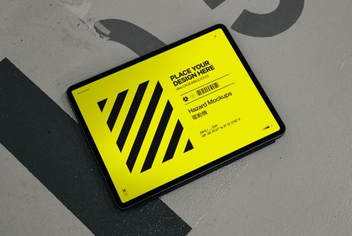 Yellow tablet mockup with diagonal stripes on urban concrete floor, editable digital design template for graphic designers.