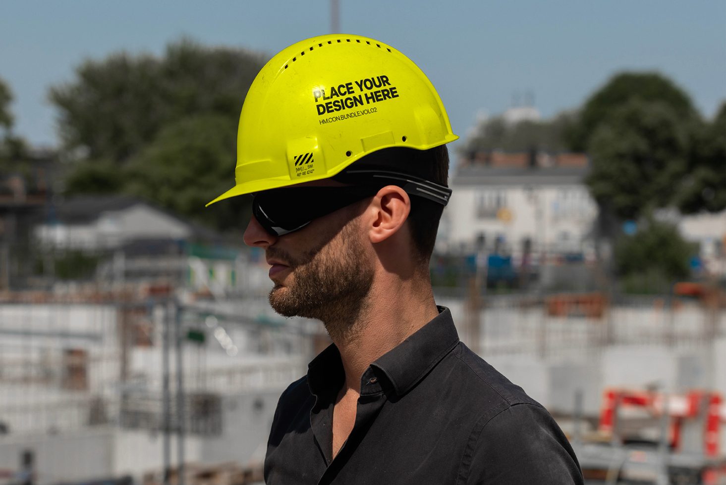 Worker in hard hat with editable design space in construction setting, ideal for mockup graphics in branding and safety themes.