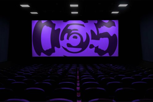 Cinema hall with empty seats and a large display showcasing abstract purple graphic design, ideal for mockup presentations.