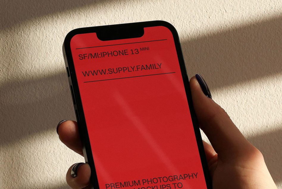 iPhone 13 Mini mockup with bright red screen in hand with natural window shadow