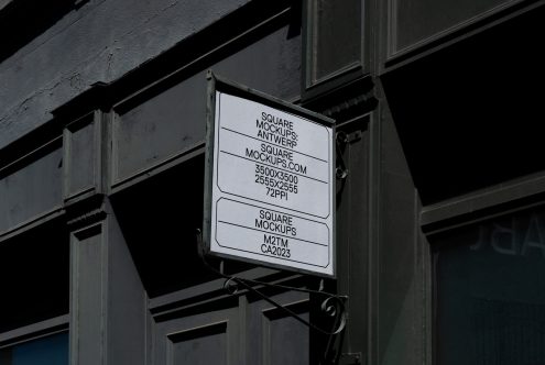 Metal-framed window sign with white background hanging on industrial storefront