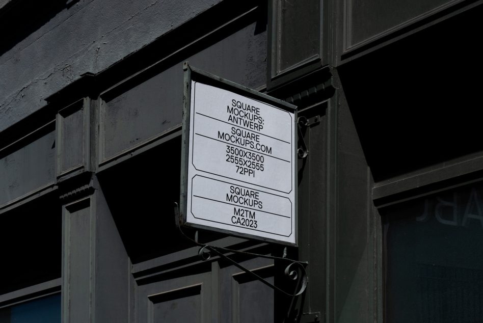 Metal-framed window sign with white background hanging on industrial storefront