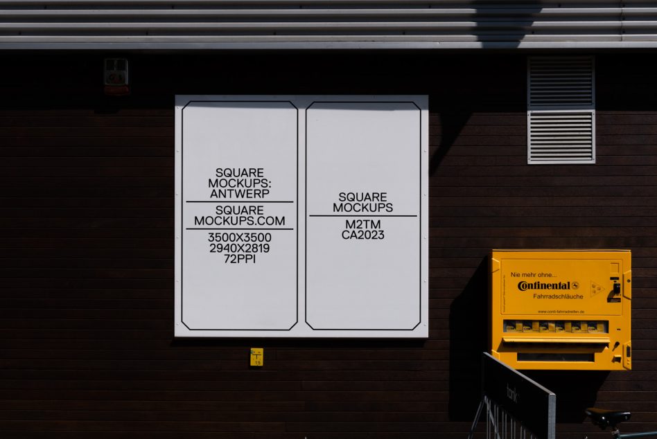 White storefront sign mounted on dark brick wall next to yellow vending machine