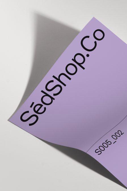 Curved purple page showing SedShop.Co text at an angle with shadow