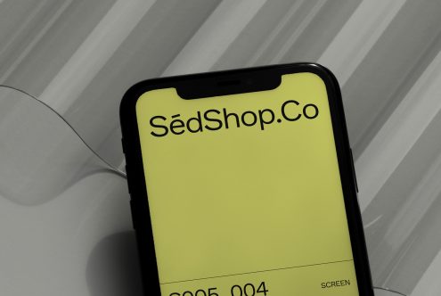 Yellow phone display with SedShop.Co branding on subtle striped surface