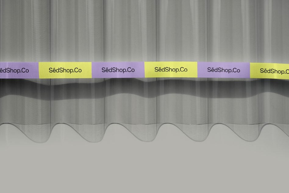 Corrugated metal backdrop with alternating purple, yellow, plus white branded ribbon labels