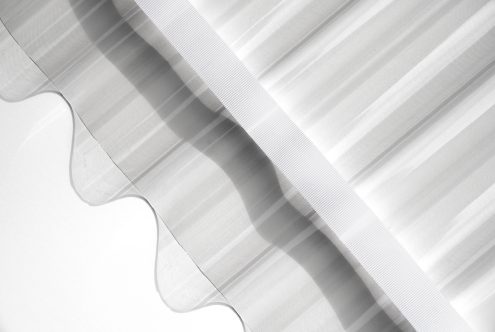 Layered white ribbons with corrugated texture creating shadow depth