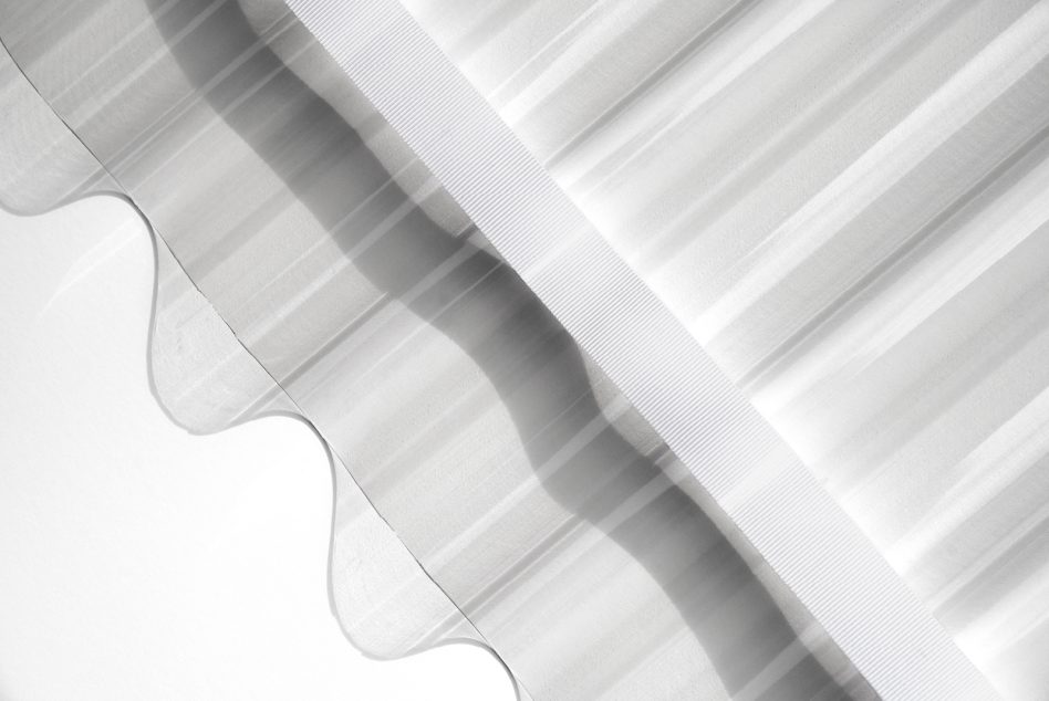 Layered white ribbons with corrugated texture creating shadow depth