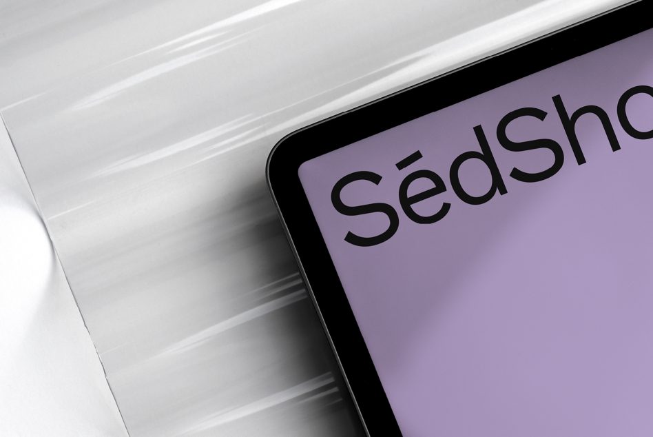 Tablet showing partial SedShop branding on lilac surface with soft lighting