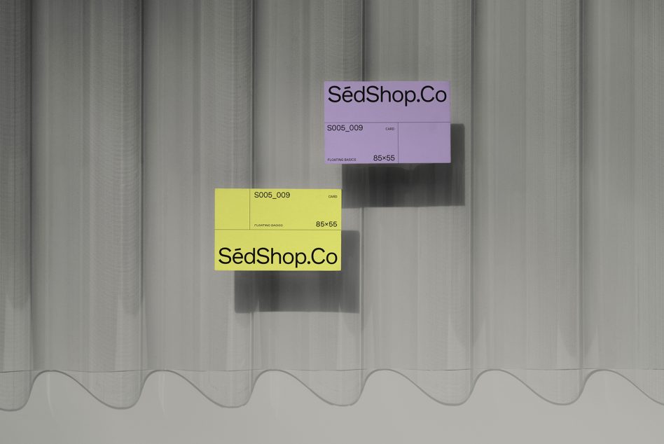 Stacked business cards in purple, yellow on fabric backdrop with wavy edges