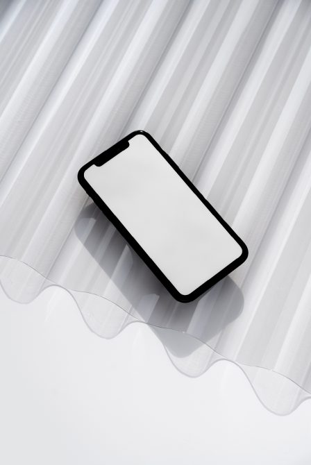 Blank iPhone screen mockup on striped gray background with wavy overlay