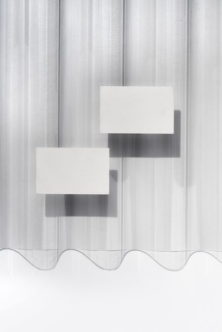 Two blank white business cards layered on sheer white curtain with dramatic shadows