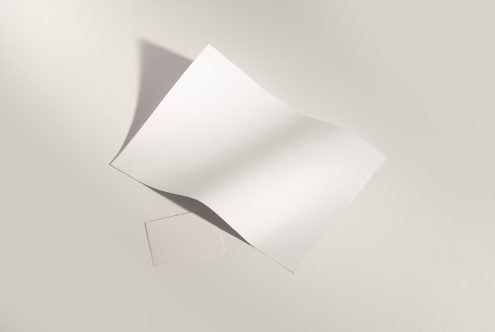 Blank white business cards fanned out with soft shadows on neutral background