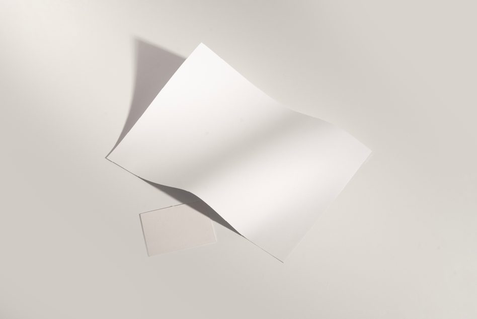 Blank white business cards fanned out with soft shadows on neutral background