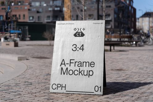 White A-Frame sign standing in open plaza with city buildings blurred behind