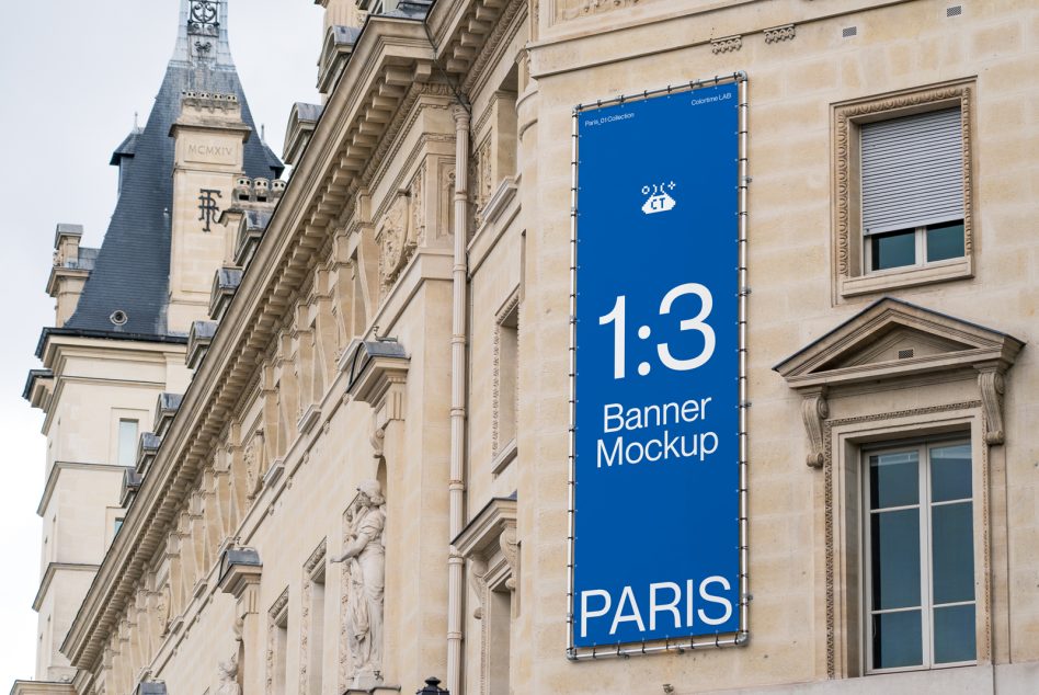 Tall blue banner with white text on ornate Parisian building with tower backdrop
