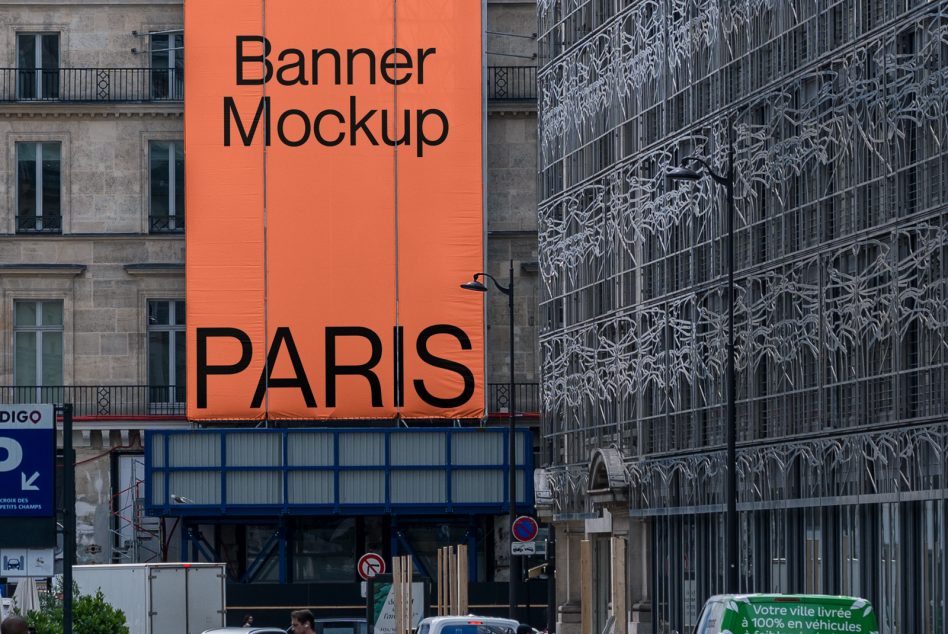 Large orange rectangular banner on Paris street storefront with bold text