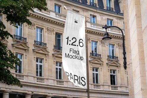 White vertical flag hanging on Parisian building facade with 1:2.6 ratio text