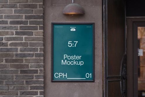 Framed poster mockup on dark brick wall with dome lamp, teal background