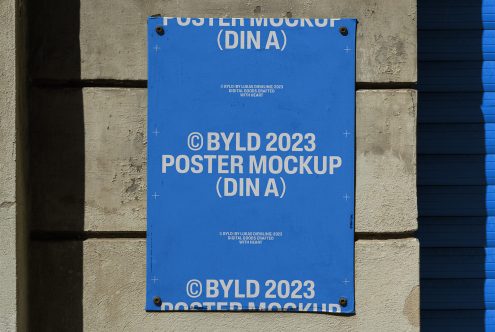 Blue poster mockup attached to a concrete wall with shadows, showcasing design presentation for digital asset marketplace, labeled BYLD 2023.