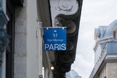 Blue vertical sign clipped to rod showing 1:1 ratio mockup on facade
