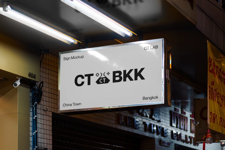 Clean white storefront sign showing CT BKK logo under bright linear lights on dark street