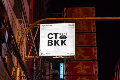 White backlit sign displaying CT BKK in bold black letters on city street at night
