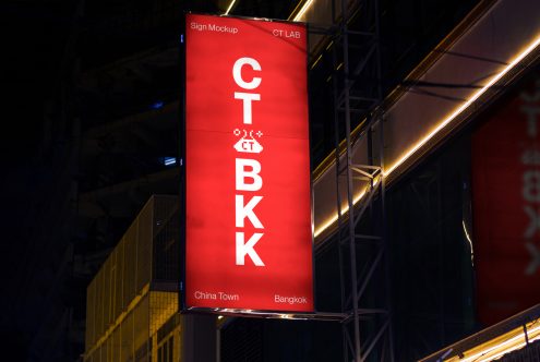 Tall red vertical sign at night with stacked white letters spelling out CT BKK in Bangkok's Chinatown