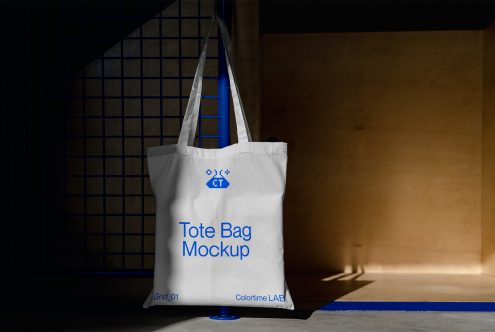 Natural canvas tote bag showing blue pixel branding on minimalist backdrop