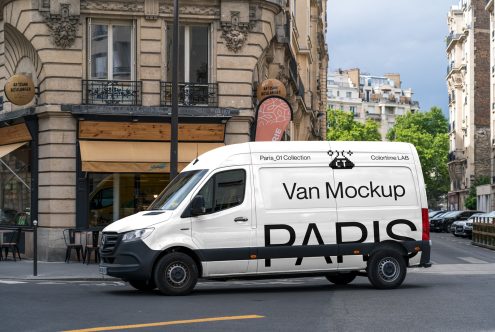 White van with black text parked on Paris street, Haussmann building behind
