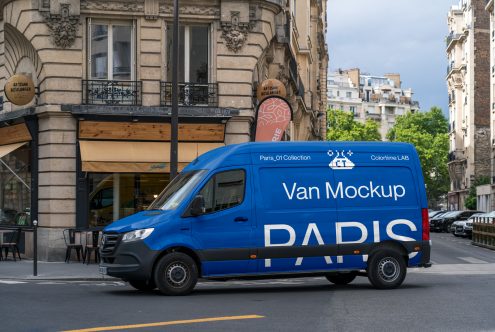 Bright blue van with white text on Parisian avenue, classical architecture backdrop