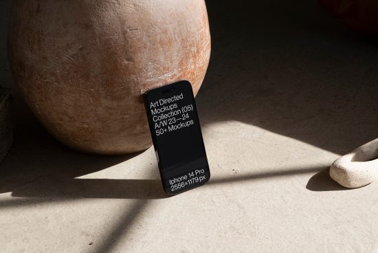 Smartphone mockup on concrete surface next to clay pot, natural light, modern design, featuring Art Directed Mockups, ideal for showcasing apps and websites in a realistic setting.