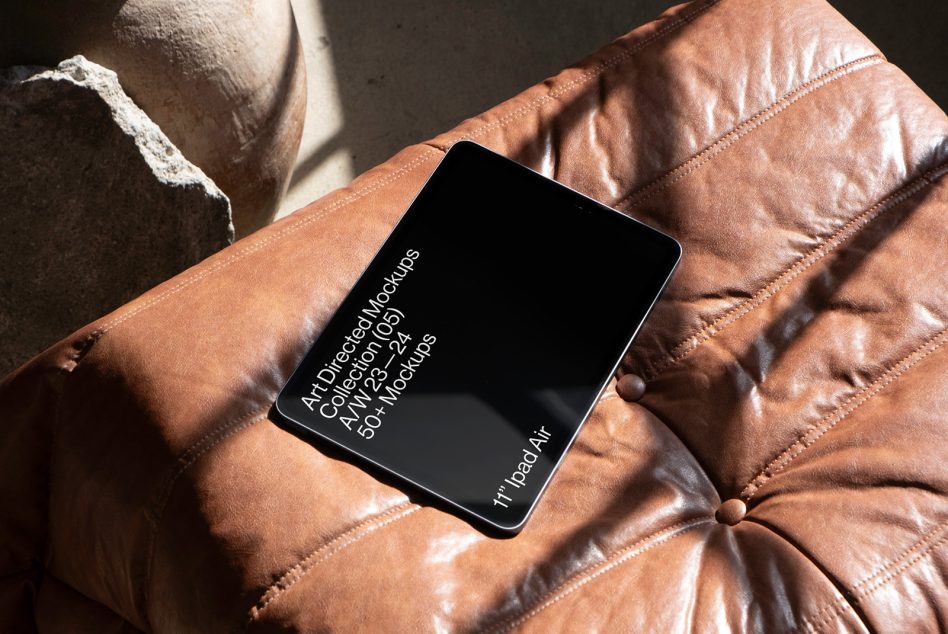 Digital tablet mockup on leather sofa with text, realistic device display for presenting designs, templates, and UI work.