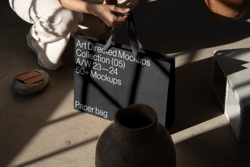 Art Directed Mockups collection paper bag, designer holding tote with text, in a creatively lit studio setting perfect for mockup assets.