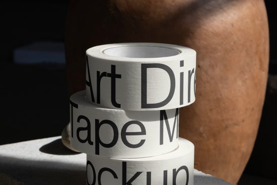 Roll of tape with "Art Director" text mockup in natural lighting, showcasing bold font, ideal for packaging design and branding.
