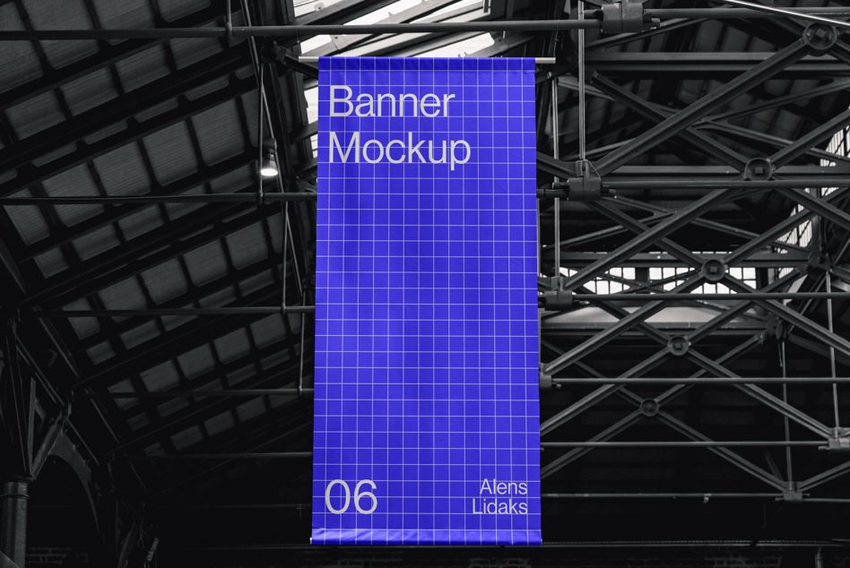 Vertical banner mockup hanging in industrial warehouse setting, ideal for graphic designers to display advertising designs.