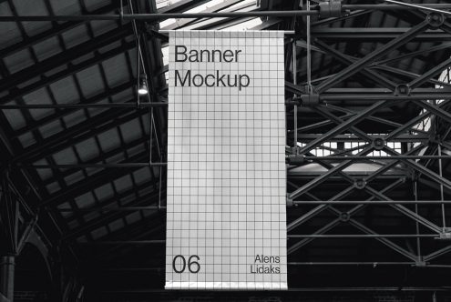 Large vertical banner mockup hanging in an industrial interior setting, grid design for advertising presentation, clear and editable.