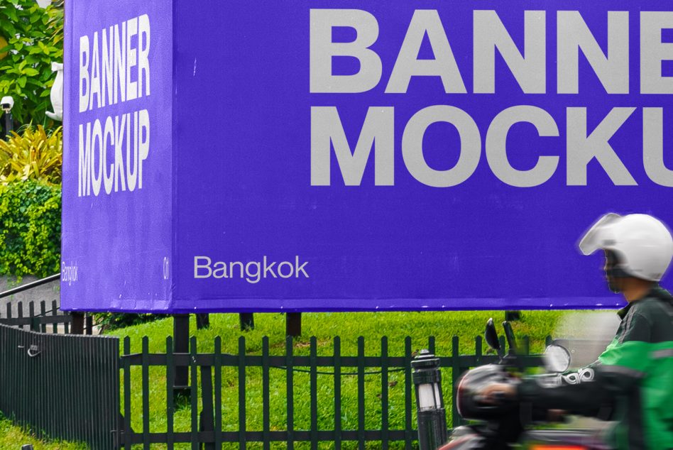 Outdoor billboard mockup in urban setting with motorcyclist passing by, ideal for designers to display ads, located in Bangkok.