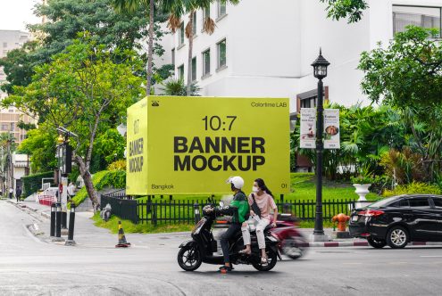 Urban billboard mockup on city roadside with green branding space, vehicle, and pedestrian presence, ideal for designers and advertising.