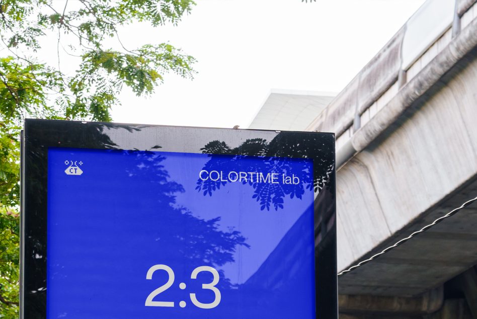 Outdoor billboard mockup with a blue screen and tree shadow overlay, urban setting with concrete structures, useful for designers.