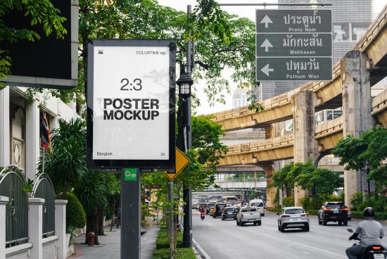 Urban outdoor poster mockup on a street sign with trees and city traffic in the background, perfect for designers to showcase billboard designs.