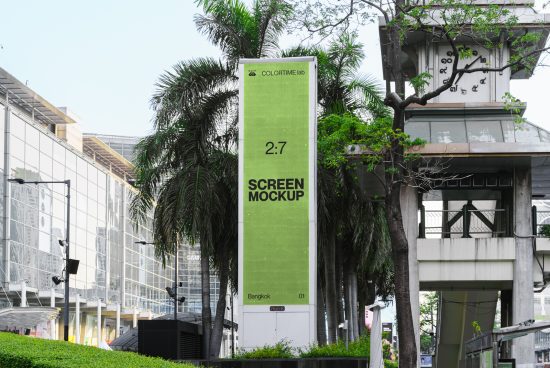Outdoor billboard screen mockup in urban setting surrounded by trees, ideal for designers to display ads and graphics.