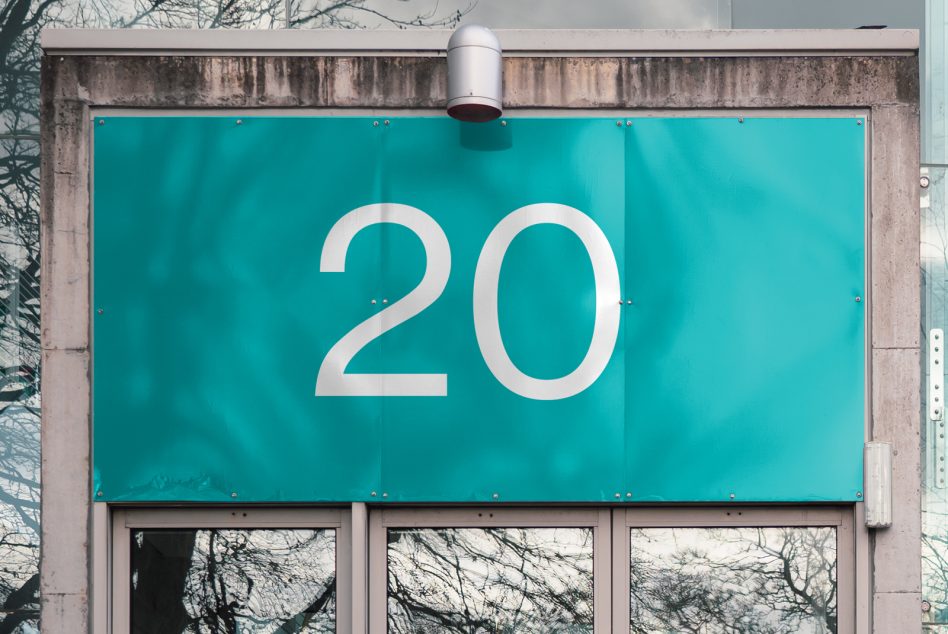 Outdoor billboard mockup with clear number 20 design, teal background, urban setting for graphic design display.