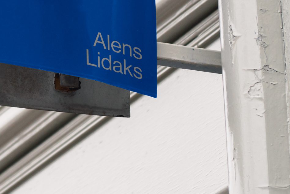 Blue signage mockup with crisp font, metal support, against textured white background, ideal for designers, branding, and identity projects.